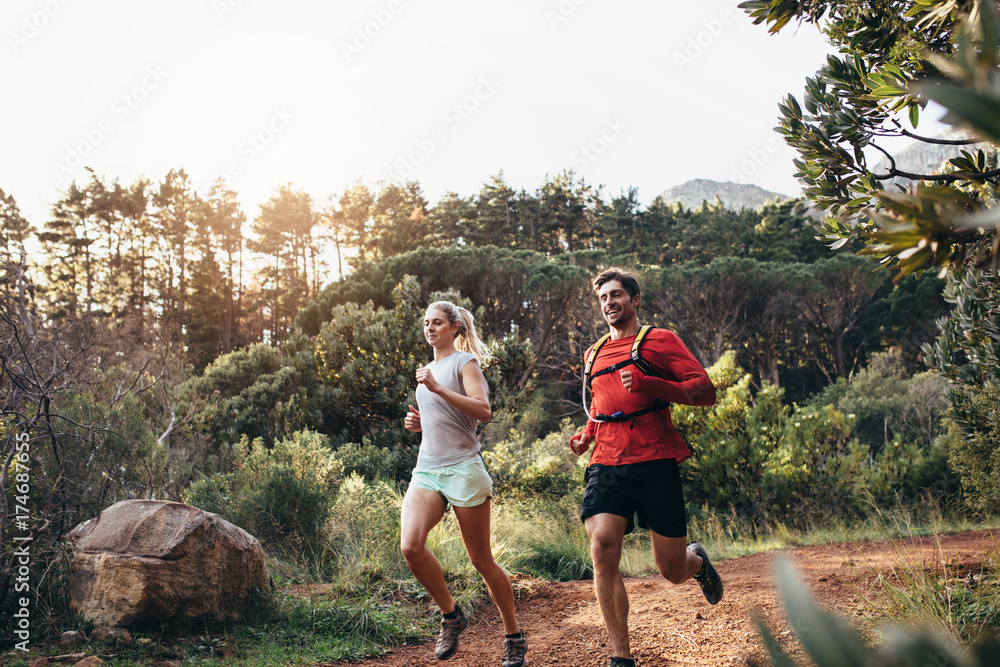 Athletic couple running together in a park