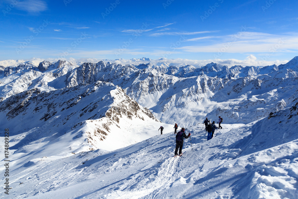 一群人穿着雪鞋徒步旅行，在奥地利斯塔拜阿尔卑斯山欣赏蓝天的山雪全景