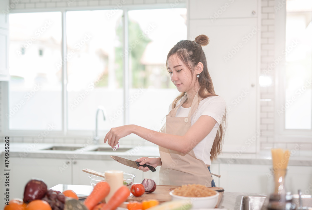 亚洲年轻女性在厨房烹饪健康食品