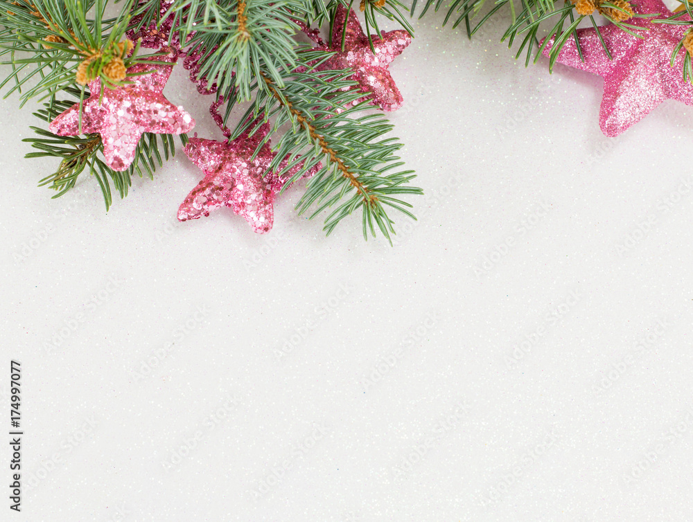 Pink star shaped ornaments hanging on a fir branch