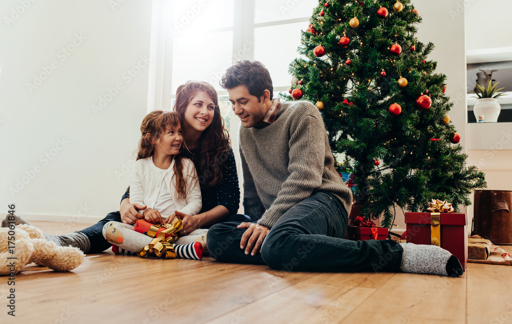 Small happy family celebrating Christmas at home.