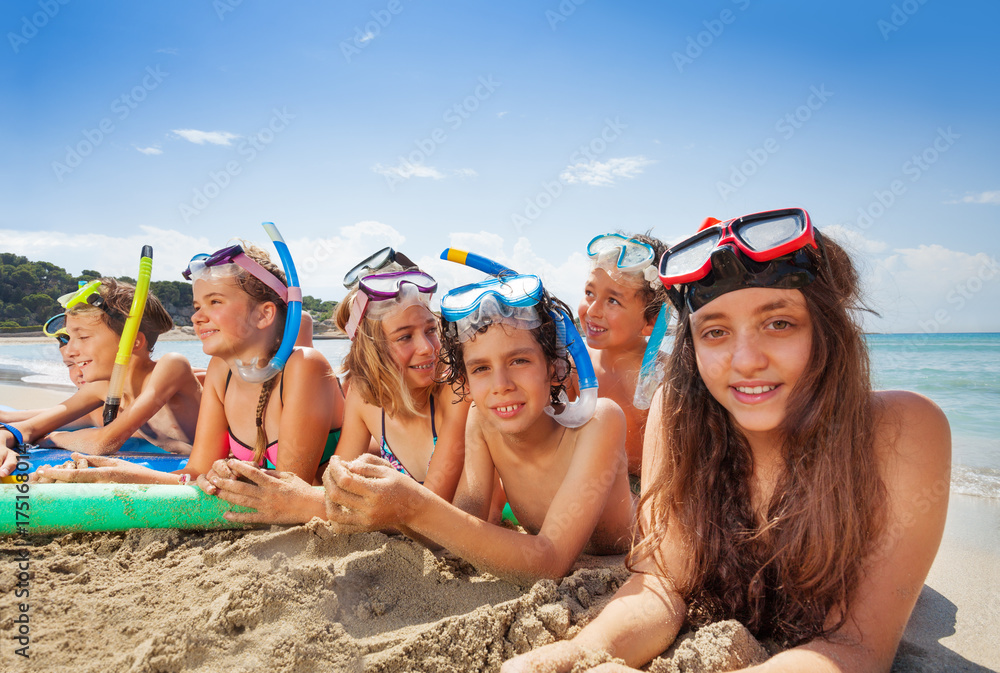 Friends lay on sand beach near the sea