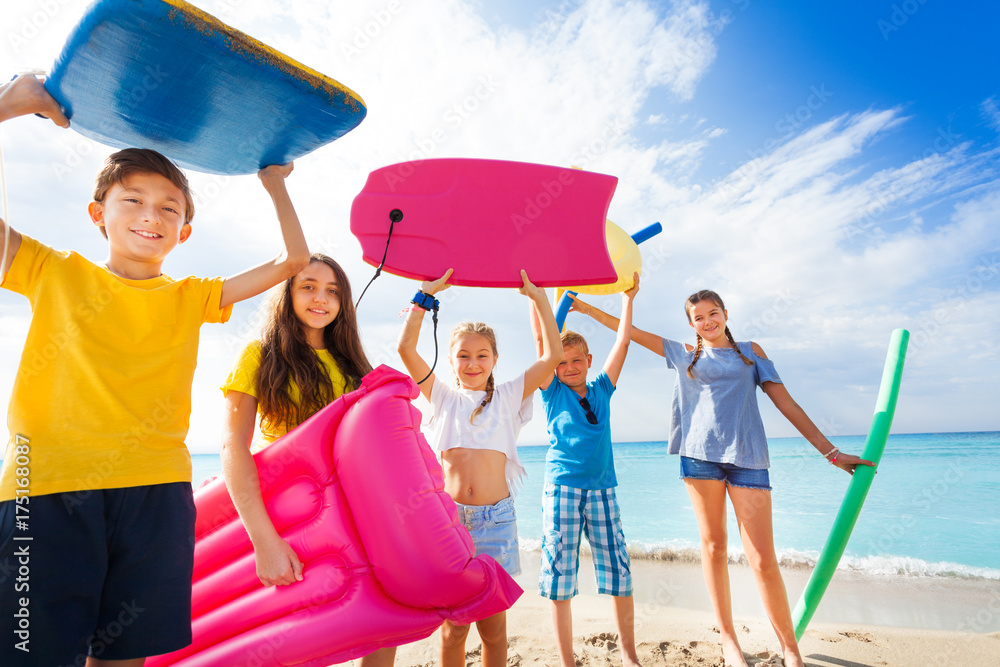 Group of happy kids came to swim on sandy beach