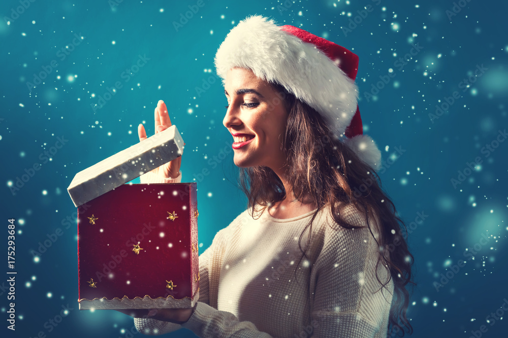 Happy young woman opening a Christmas present box