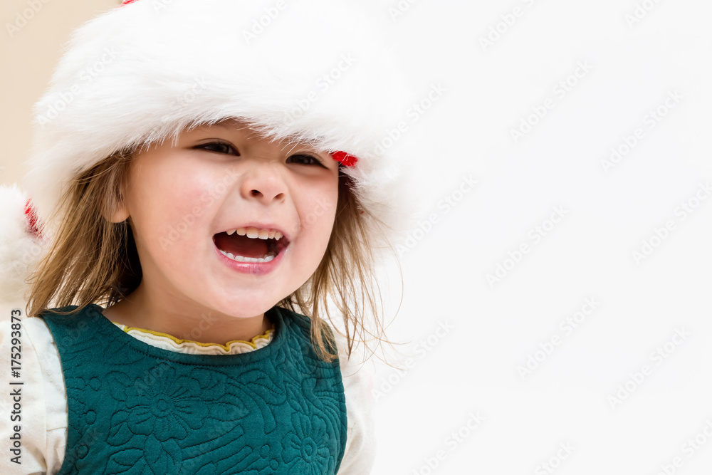 Happy Toddler gir playing in a Santa hat