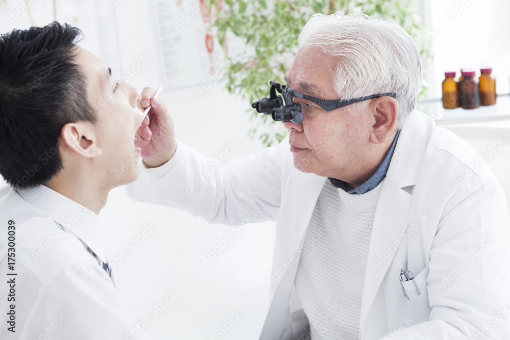 Veteran doctor inspecting oral cavity