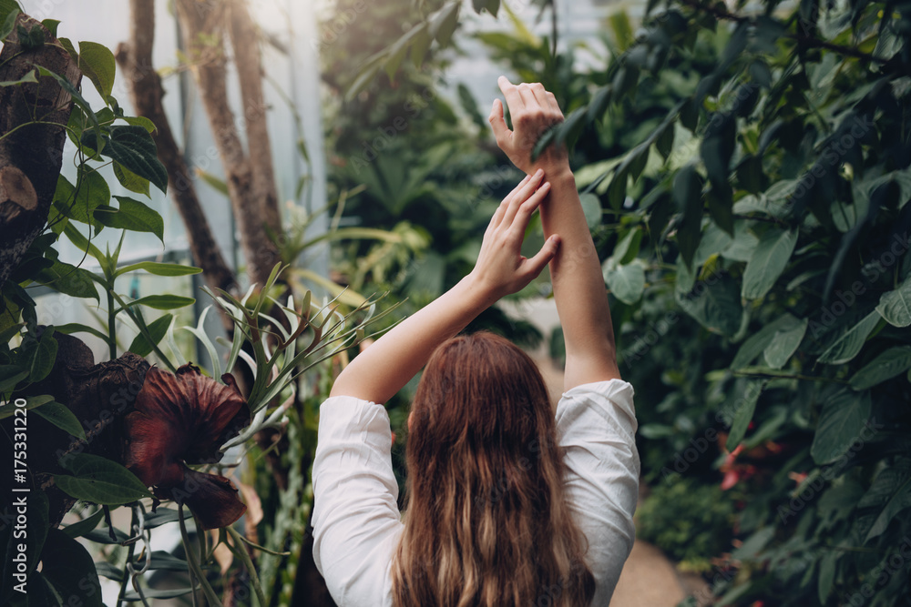 Female model standing inside plant nursery