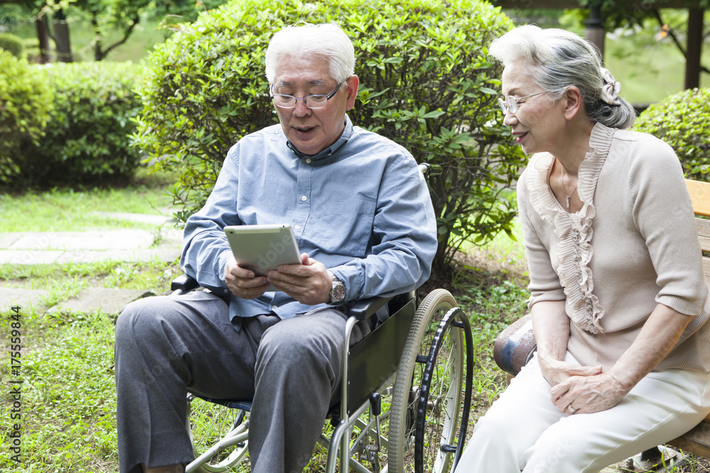 An old couple is using a tablet