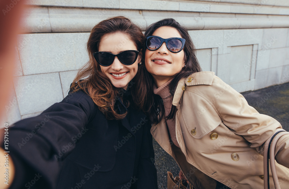 Female friends making a self portrait in the city