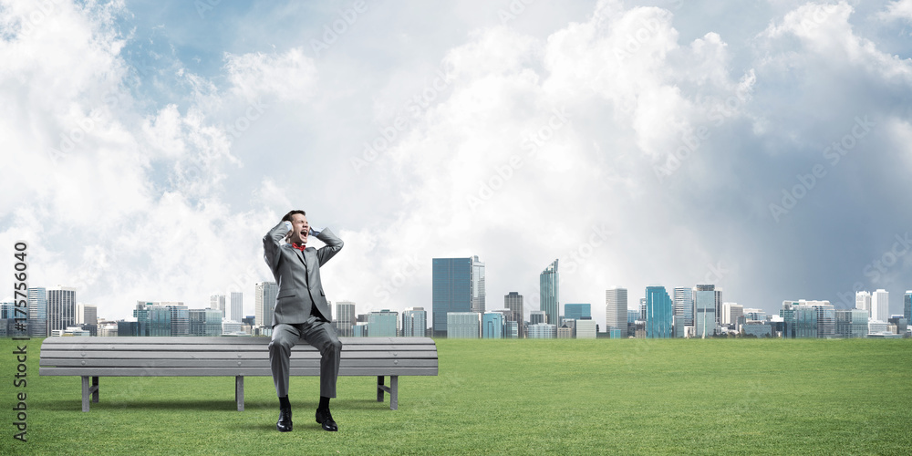 Young man in suit in park dont want to hear anything