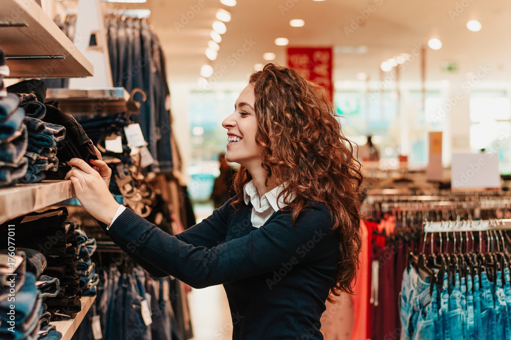 快乐的年轻女人在商店里挑选衣服。