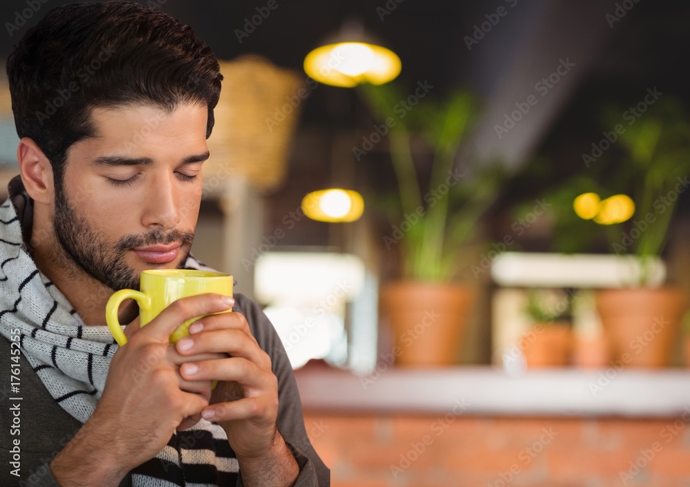 咖啡馆里戴着杯子和围巾的秋天的男人