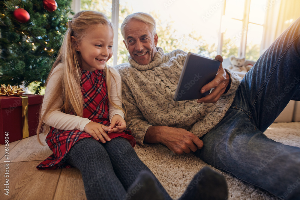 Grandfather and granddaughter having a video on digital tablet d