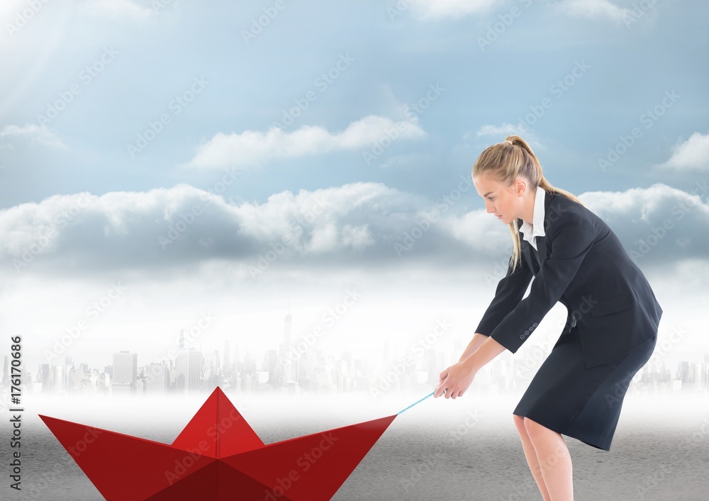 Businesswoman pulling paper boat with rope in city