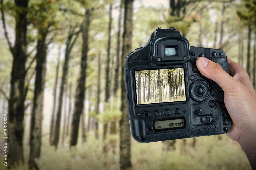 Composite image of cropped hand of photographer holding camera 