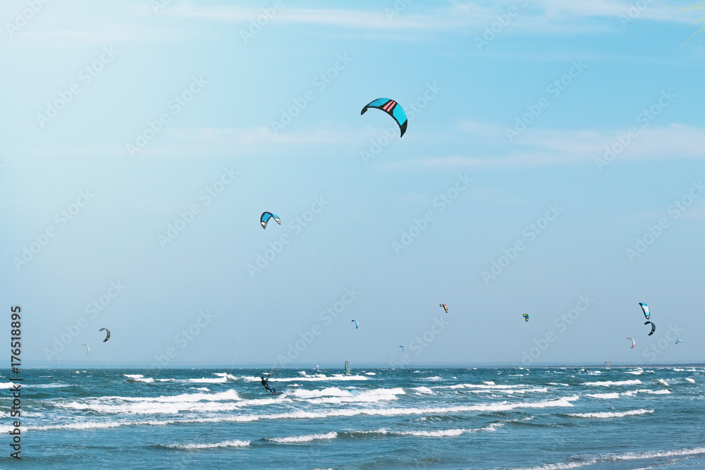 在波浪形的大海中风筝冲浪。天空背景上有许多风筝冲浪者。