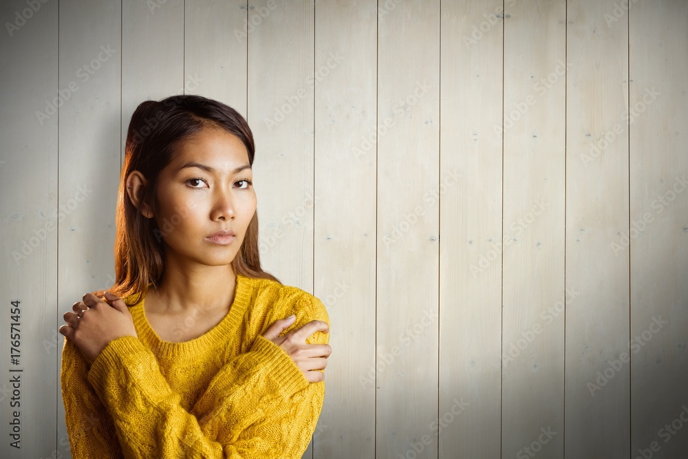 Composite image of serious asian woman with hands on shoulders