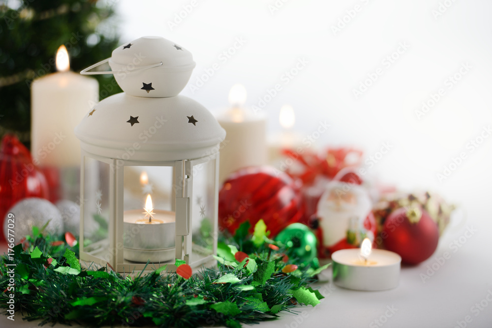 Festive Christmas decoration, lamp, candles, Christmas tree and ornaments with copyspace on white