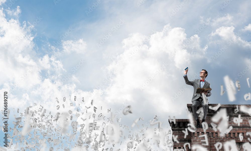 Young businessman or student studying the science and symbols fly around