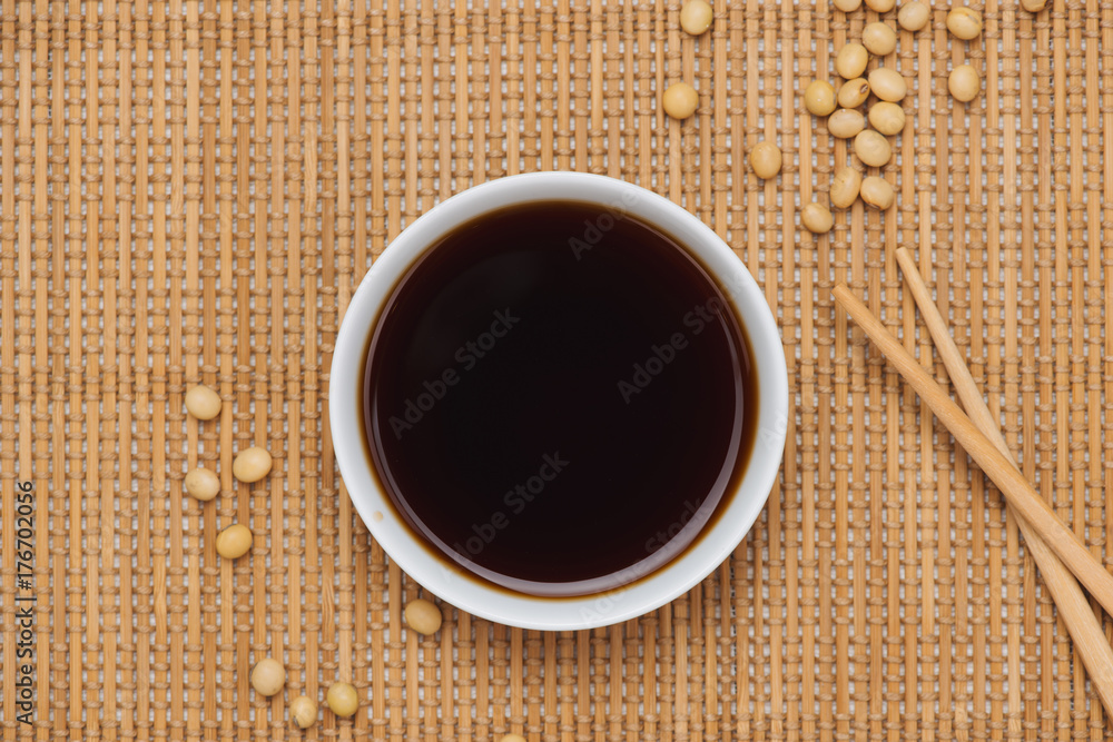 Soy sauce and soy bean with chopsticks on wooden table