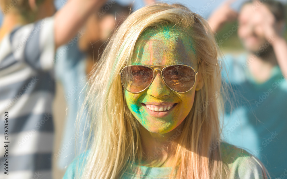 Portrait of a Beautiful Blonde Girl Celebrating Holi Festival With Her Friends. Her Face and Clothes