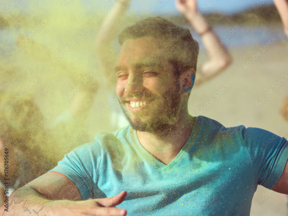 Close-up Portrait of a Muscular Man Dances in Celebration of Holi Festival With His Friends. His Fac