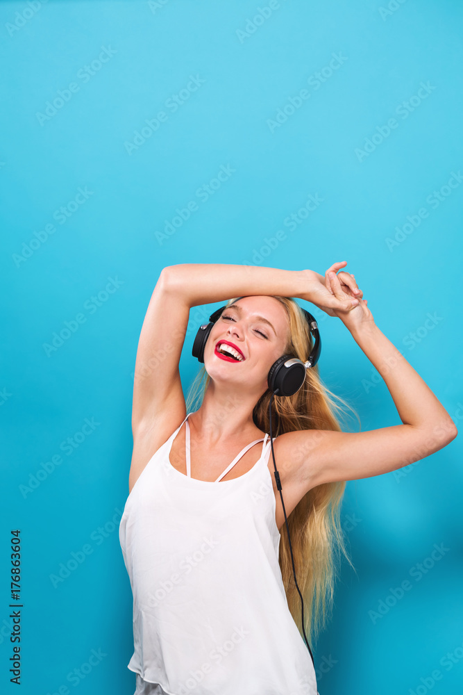 Happy young woman with headphones on a solid background