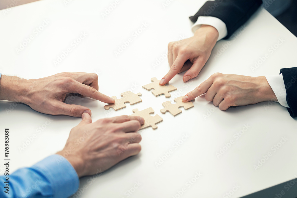 business cooperation concept - businessmens  connecting puzzle pieces