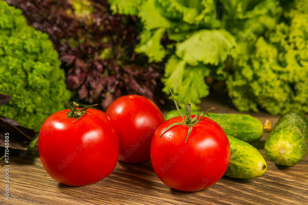 Fresh vegetables. Tomatoes and cucumbers on a wooden table. Delicious vegetarian food. Salad.