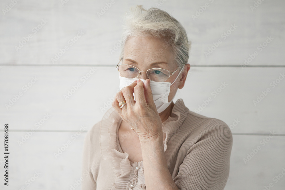 An old woman holding a mask with a mask