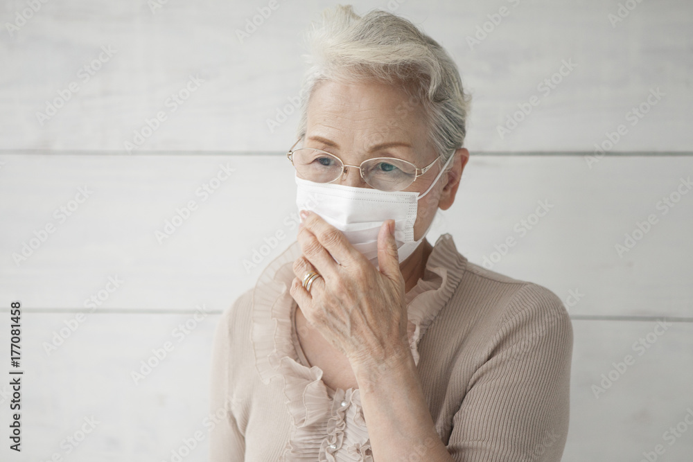 An old woman holding a mask with a mask