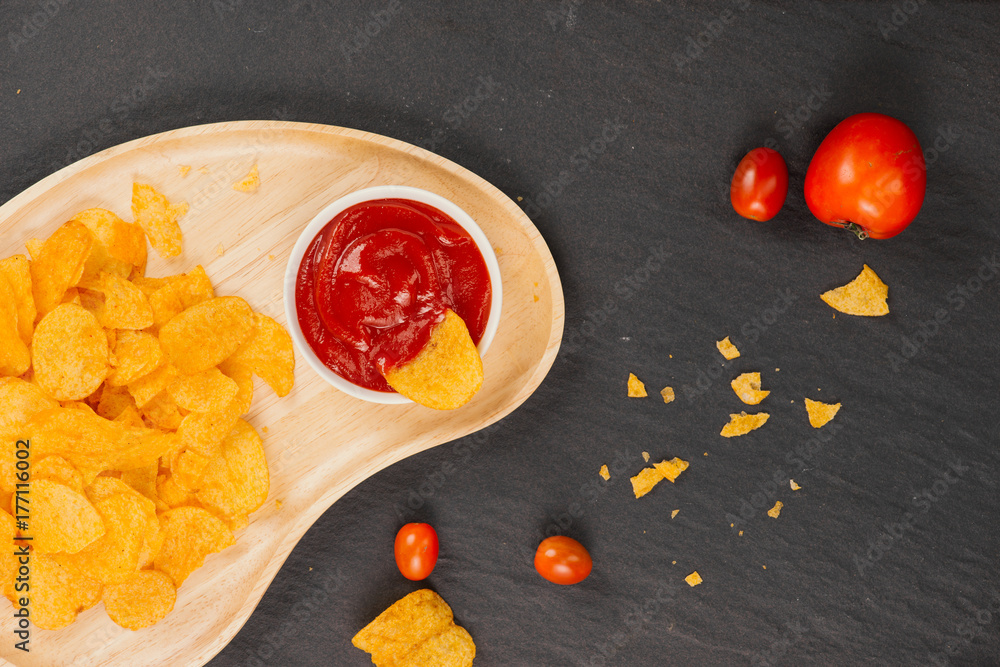 Fresh homemade crispy French fries on balck stone background.