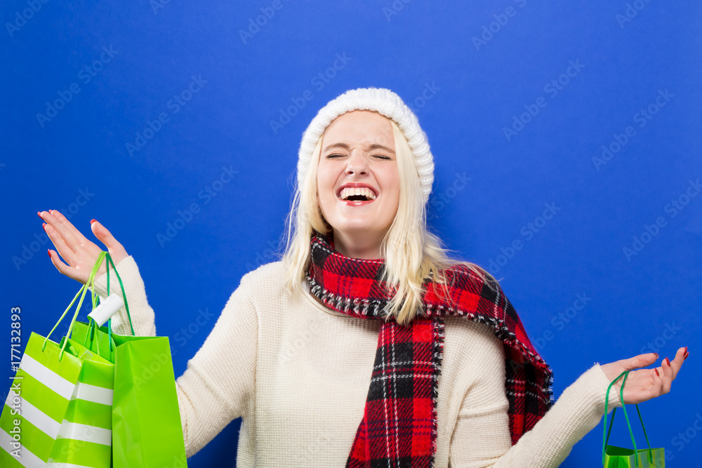 Happy young woman holding shopping bags on a solid background