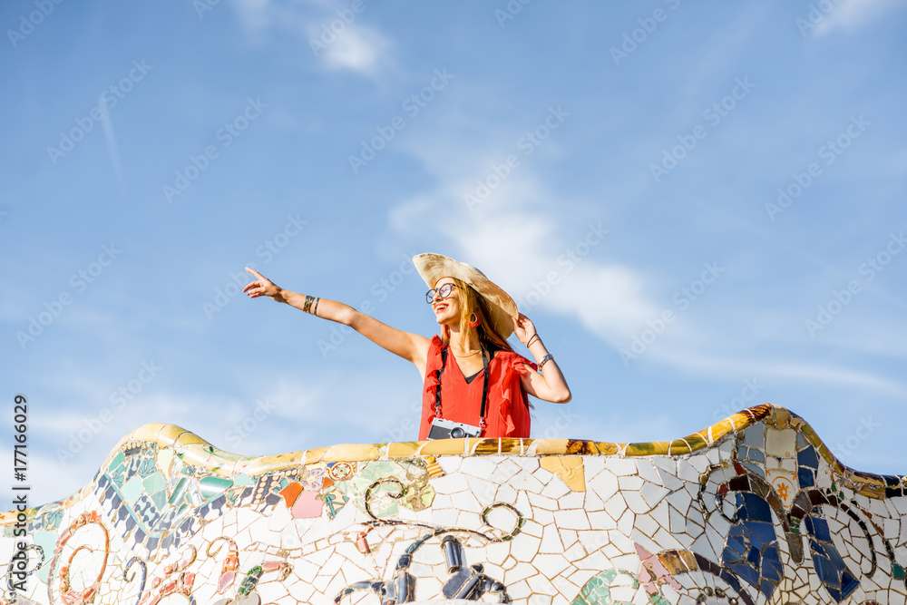 View on the beautiful terrace decorated with mosaic with happy woman tourist in Guell park in Barcel