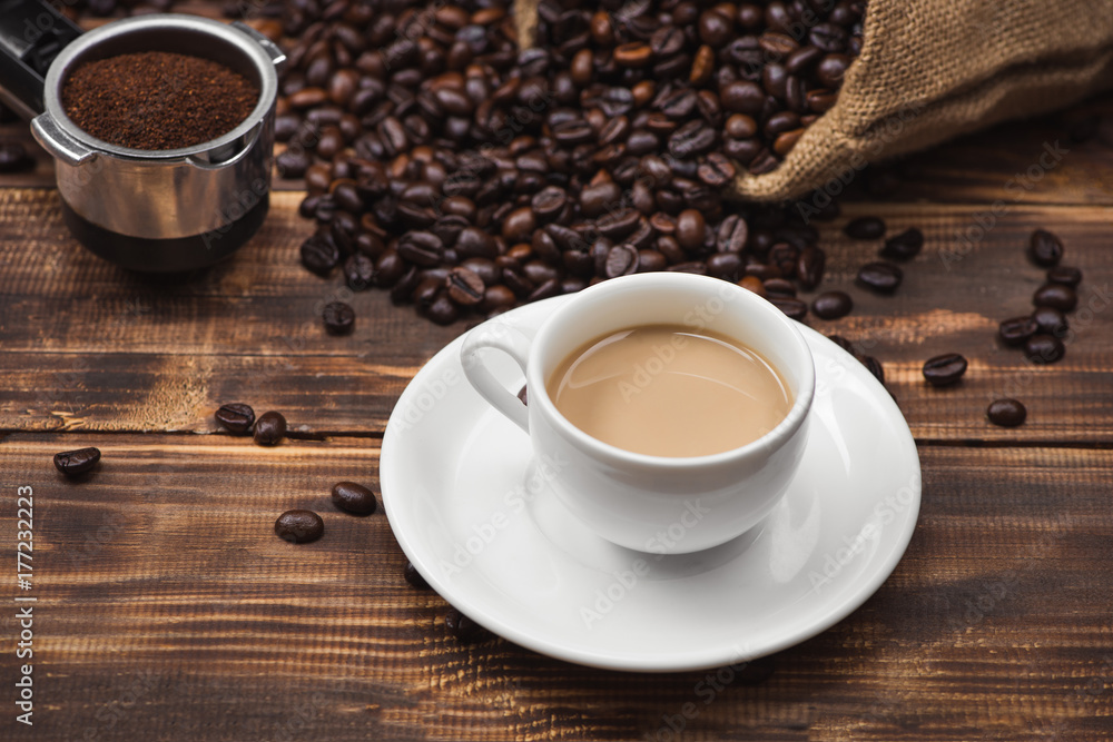 Coffee cup and beans on a rustic background