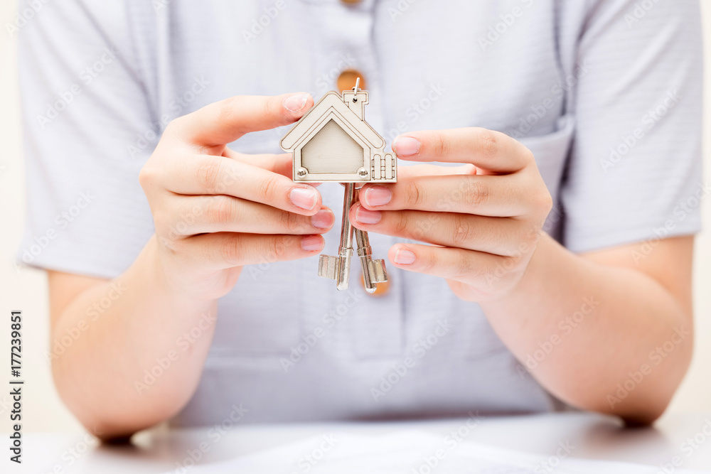 Woman hand holding home key. Concept for real estate business.