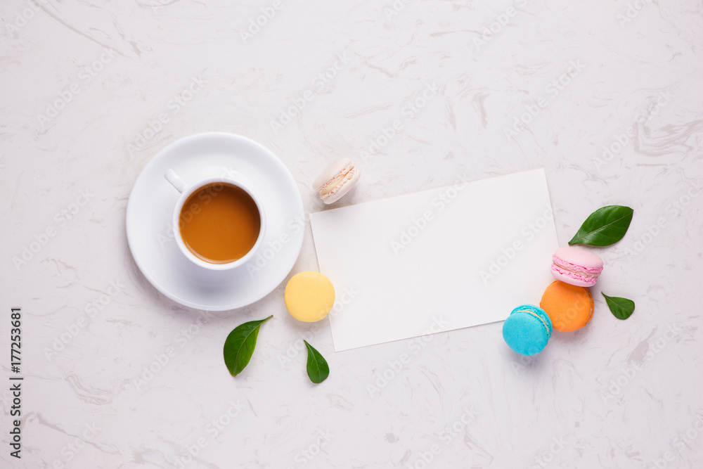 Colorful flat lay with flowers macaroons and cup of tea. Spring concept.