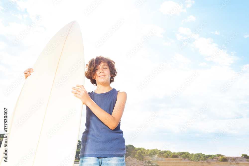 海滩上的冲浪板男孩