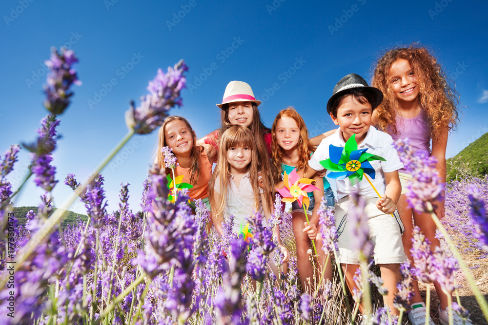 Cute kids playing with pinwheels in lavender field