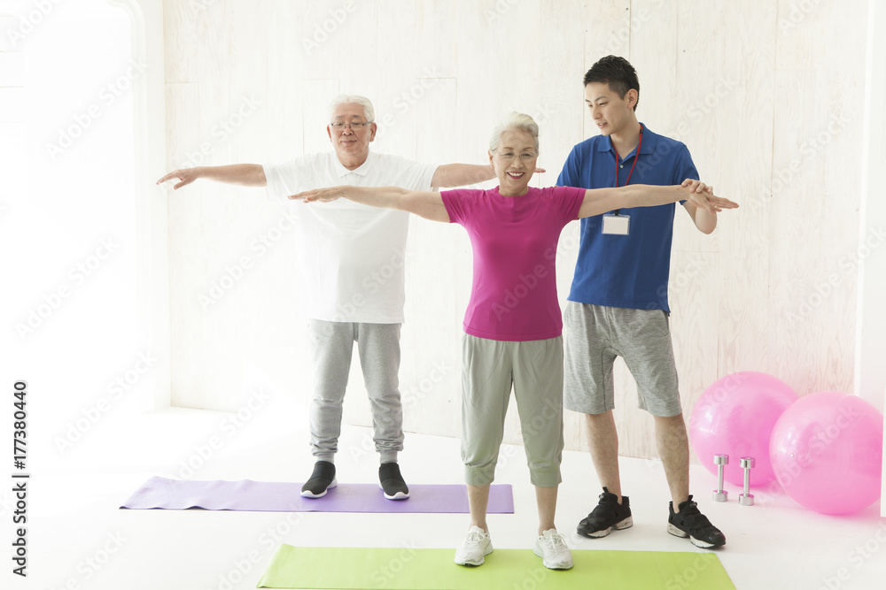 An old couple stretching their arms