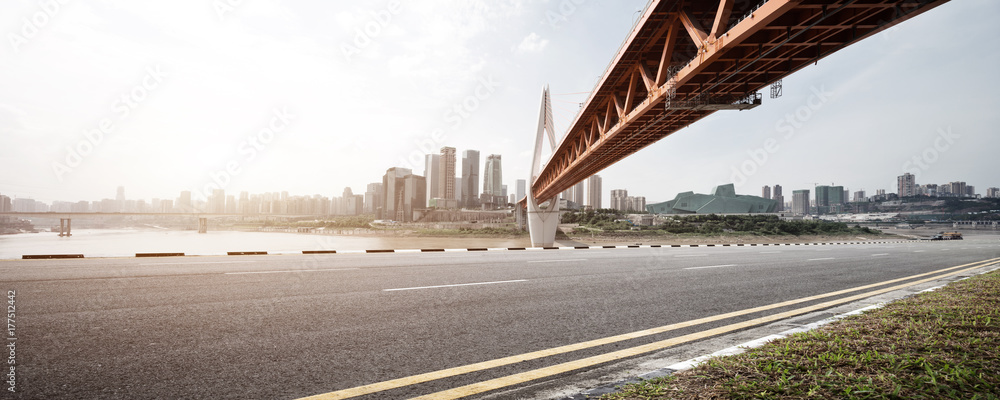 empty asphalt road with modern bridge and buildings