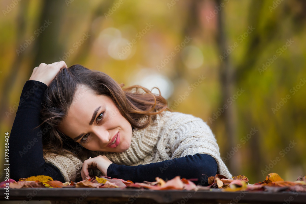 Portrait of a young beautiful woman in a park in autumn when the leaves turn colorful