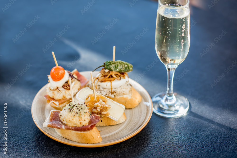 Beautiful and colorful set of pinchos, traditional spanish snack related to tapas, with glass of win