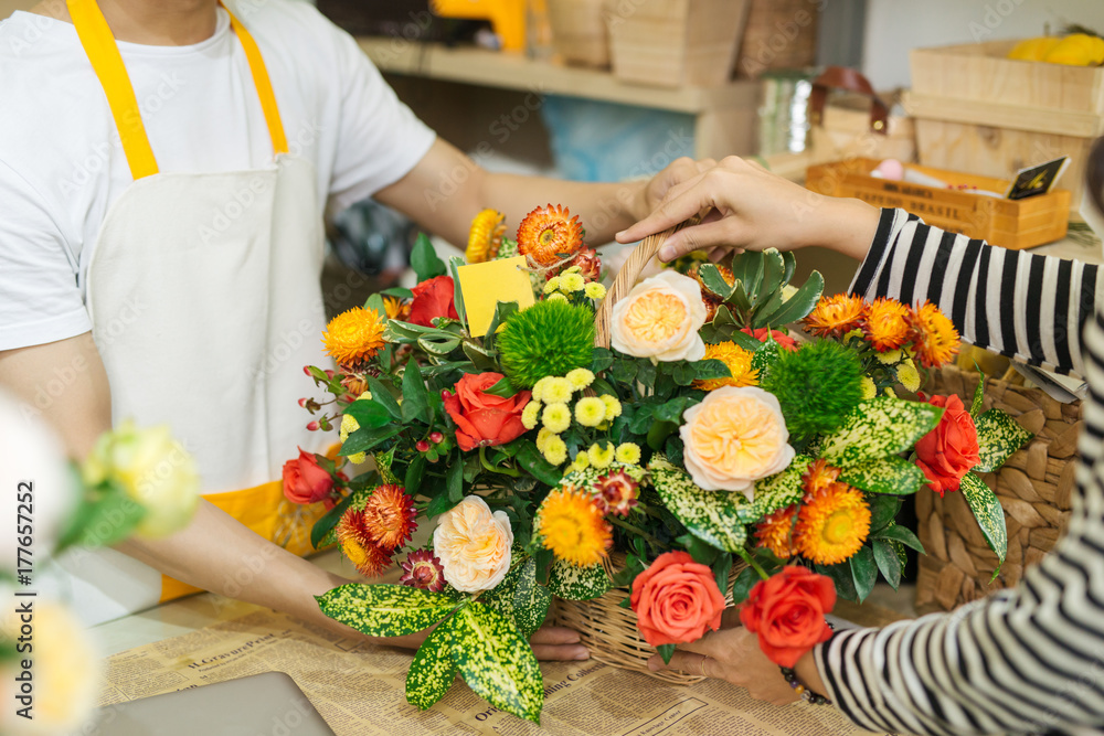 花店花艺师向一位女士赠送一束鲜花