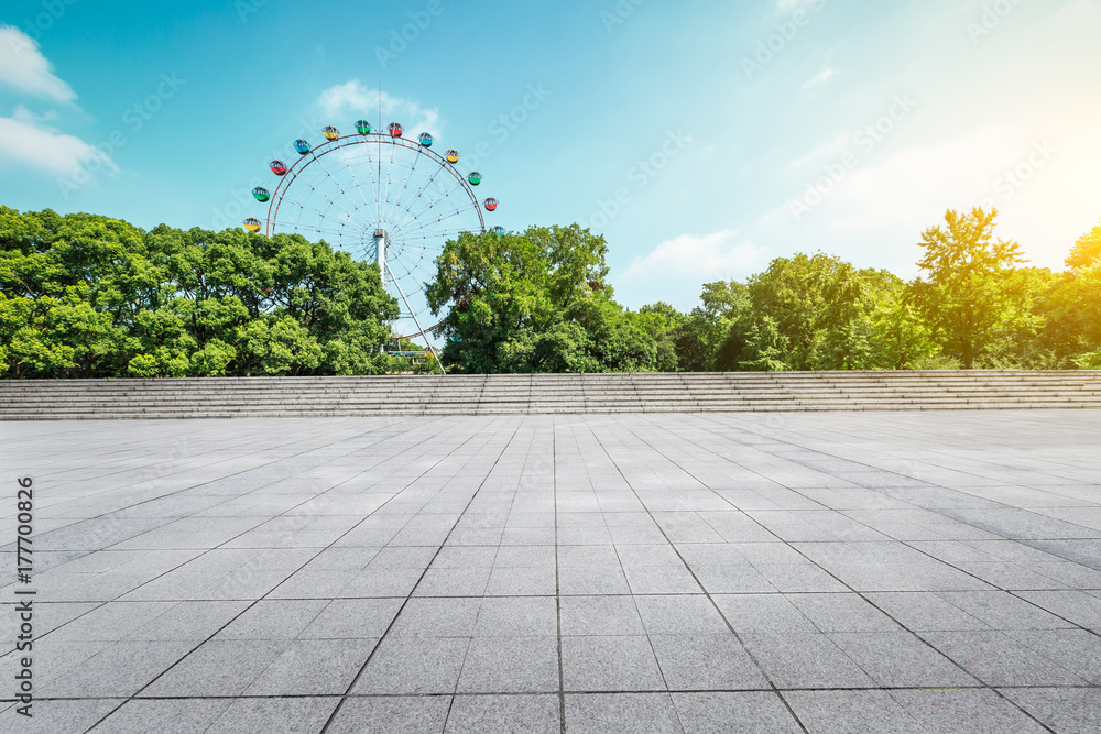 城市公园空荡荡的楼层广场和游乐场摩天轮