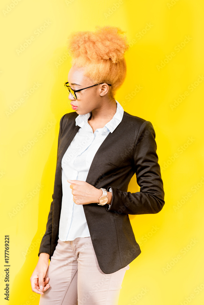 Portrait of an african business lady in casual suit and eyeglasses with beautiful hairstyle standing