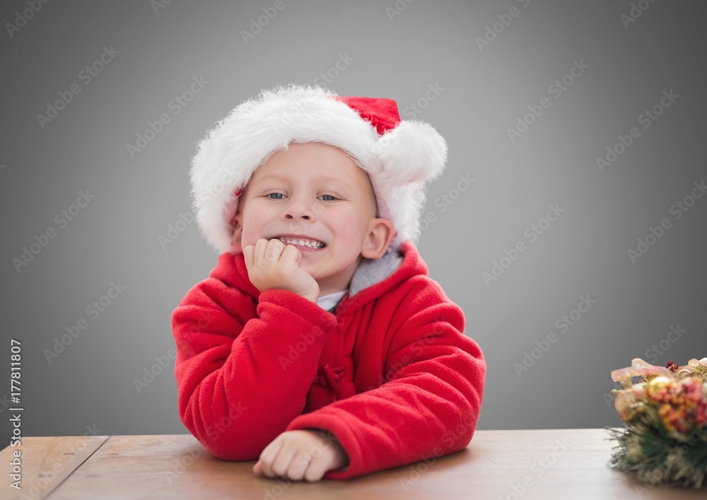 Boy against grey background with Christmas Santa hat