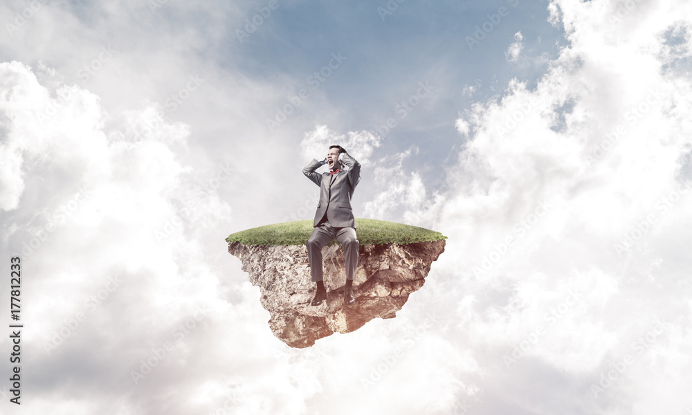 Young man on floating island do not want to hear anything