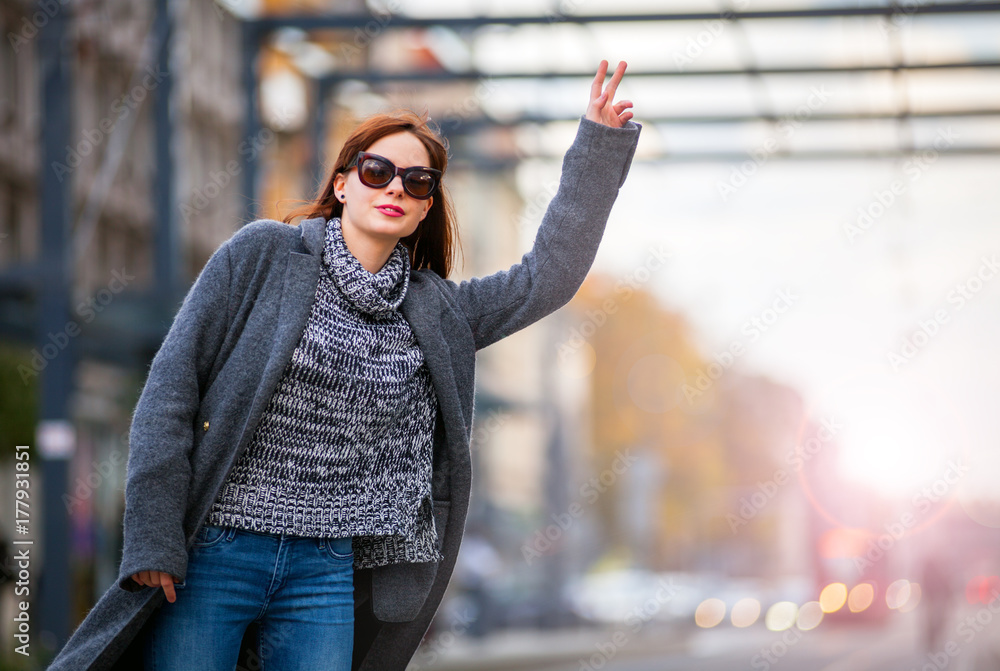 Woman at the city street calling taxi urban scene