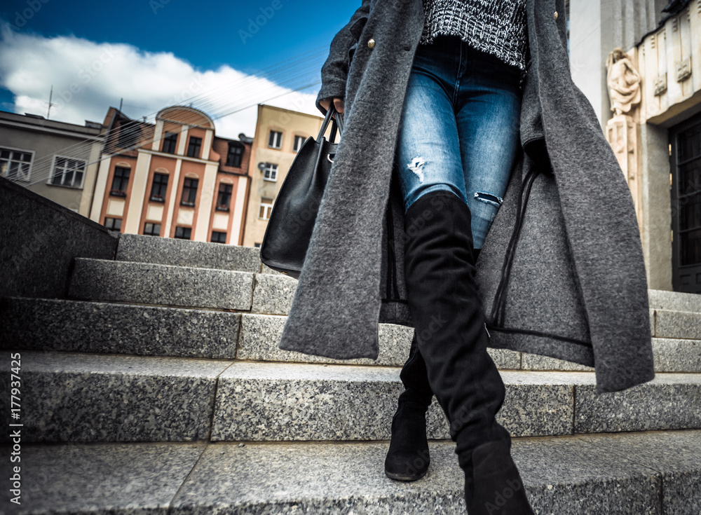 Casual fashion urban scene, trendy woman in coat walking on the street